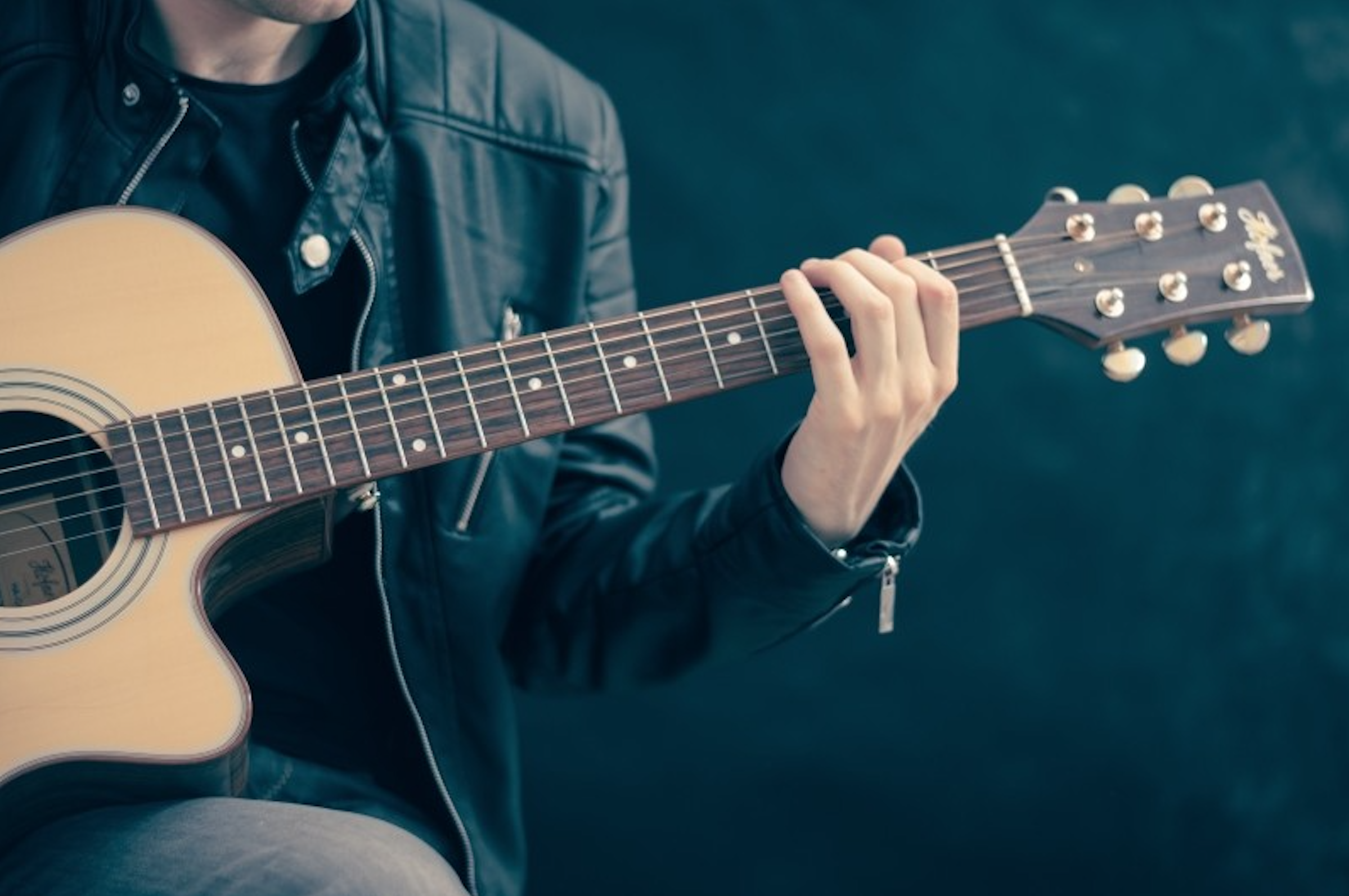 A man plays an acoustic guitar.